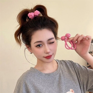 Pink knotted high elasticity hair tie shown on model hair and in hand detail