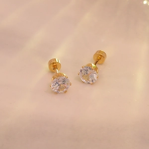 Détails de boucles d'oreilles en titane doré avec zircons ronds sertis à quatre griffes