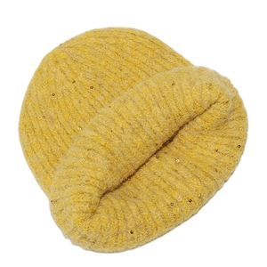 Close-up of thick yellow knit beanie with wool blend texture and golden sequins detail