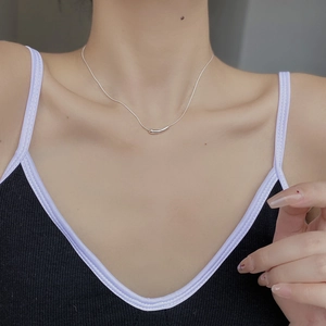 Minimalist 925 sterling silver necklace with curved pea pendant on model clavicle