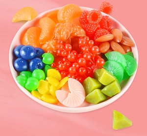 Detailansicht verschiedener Harz-Obst-Cabochons in einer Schale für DIY-Kuchendekoration