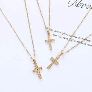 Detailed view of three gold cross pendants with sparkling white cubic zirconia inlay
