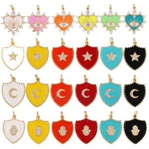 Colorful enamel evil eye, shield, star and moon charms with zircon inlays on white backdrop