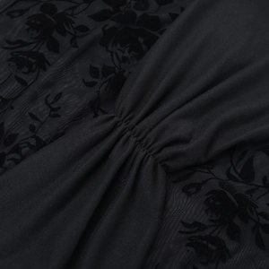 Détail de dentelle florale floquée noire et coutures plissées sur une robe moulante