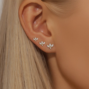 Close-up of golden marquise cubic zirconia floral stud earrings set on a model ear