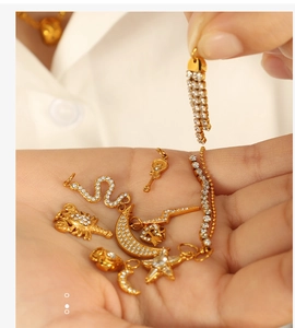 Detailed view of 18K gold plated charms with white zircon inlays on hand