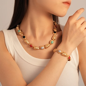 Vintage gold necklace set with colorful geometric stones on model for a retro look