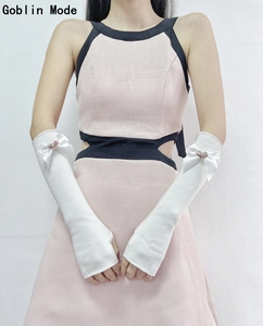 Detail of white knit arm sleeves with pink hearts and white bow accents for girls