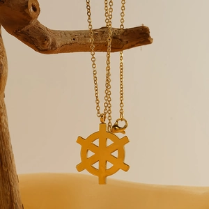 18K gold plated stainless steel rudder pendant necklace on a natural wooden branch