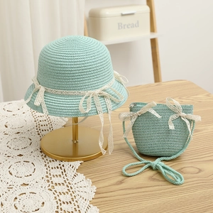 Close-up of mint green straw hat and matching purse with elegant white lace bows