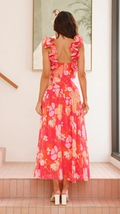 Détail des bretelles à volants et du dos nu sur une robe maxi à fleurs