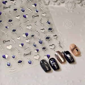 Gothic silver heart nail stickers with purple opal eyes shown on white texture
