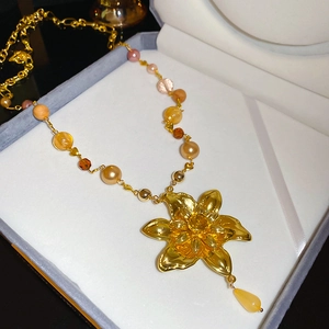 Détail du pendentif fleur dorée haut de gamme avec collier en perles colorées rétro