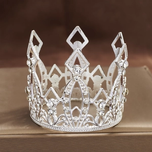 Detailed close-up of a silver hollow crown with round and teardrop-shaped rhinestones
