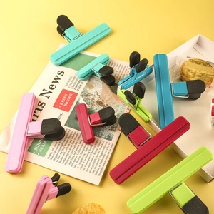 Set of 9 colorful T-style plastic food sealing clips for snack bags on yellow background