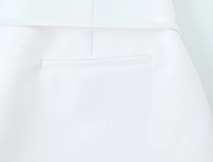 Macro shot of white tailored shorts with clean welt pocket and fine woven fabric detail