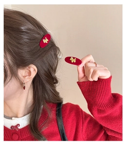 Detailed view of wine red velvet hair clips with gold puppy charms worn on hair