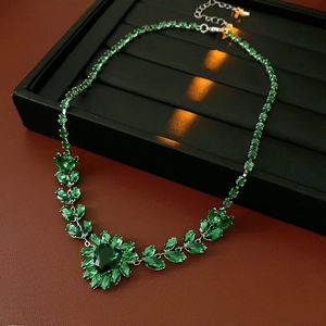 Detailed view of luxury emerald drop pendant with leaf design and sparkling crystals