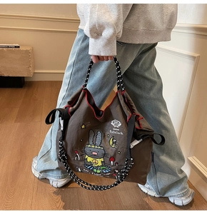 Detail of coffee brown nylon tote bag with cartoon rabbit embroidery and woven handles