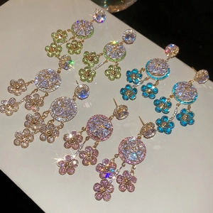 Detail view of four crystal floral tassel earrings in white, green, blue and pink colors