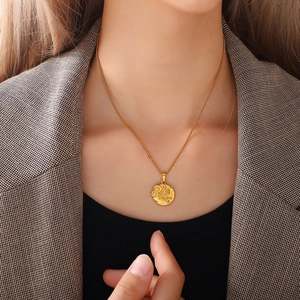 Minimalist golden daisy flower pendant necklace on a professional model in grey suit