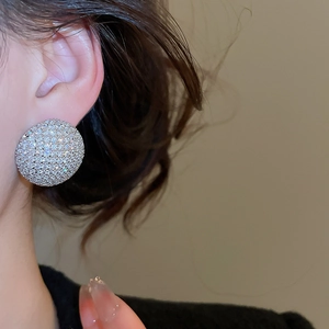 Vue latérale macro d'un mannequin portant de grandes boucles d'oreilles rondes en argent
