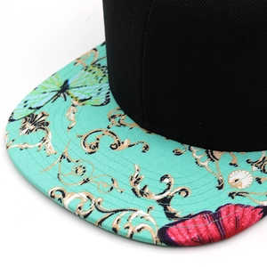 Close-up of hip hop snapback brim with colorful butterfly floral pattern over mint green