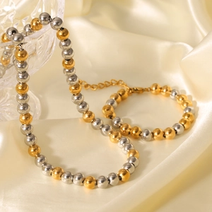 Ensemble collier et bracelet à billes bicolores or et argent sur satin élégant