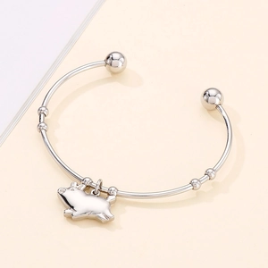 Vue détaillée du bracelet jonc ouvert argenté orné d'un pendentif cochon en métal poli