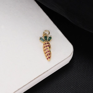 Macro detail of 18K gold plated carrot pendant with pink and green zircon stones