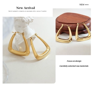 Detail of 18k gold plated U-shaped triangular earrings on artistic plaster bust