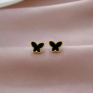 Macro detail of butterfly stud earrings with black agate and gold titanium steel frame