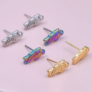 Three tiny astronaut stud earrings in silver, rainbow and gold finish on pink background