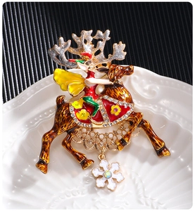 Macro shot of colorful enamel Christmas reindeer brooch with rhinestone snowflake charm