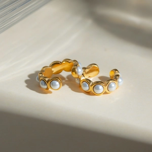 Macro view of C-shape 18k gold stainless steel clip earrings with white pearls