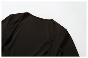 Detailed macro view of the round neckline and smooth stitching on the dark brown yoga top
