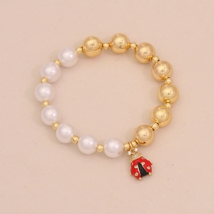 Detailed view of beaded bracelet with white pearls and red enamel ladybug charm