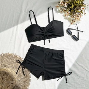 Detail view of black two-piece swimsuit with adjustable drawstrings and flat angle bottoms
