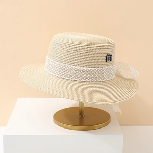 Eleganter Strohhut in Beige mit weißem Spitzenband und dekorativem Buchstaben-Detail