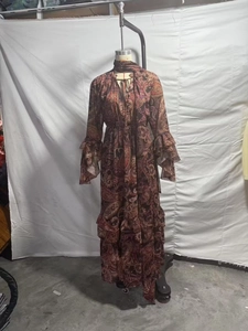 Détail d'une robe longue bohème bordeaux à motif cachemire avec ourlet volanté et lien noué
