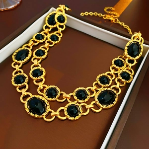 Detailed view of vintage gold double-layer necklace with black stones in a gift box