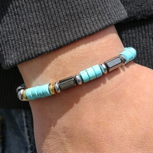 Detailed macro view of beaded bracelet with turquoise stones and metallic spacers