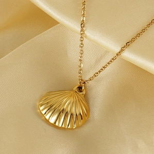 Vue macro du pendentif coquillage en or 18 carats sur fond en soie satinée élégante