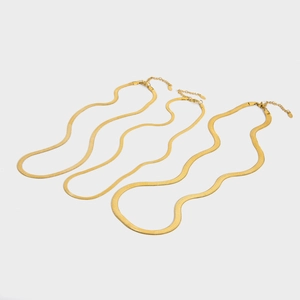 Close-up of three layered 18K gold-plated flat snake chains with lobster clasps