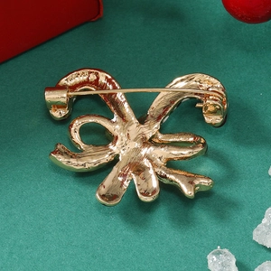 Macro view of the secure golden metal pin and back structure on the Christmas brooch