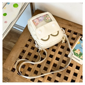 Detail of cream canvas crossbody ita bag with clear window display and smile pocket