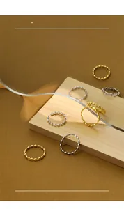 Minimalist S925 sterling silver beaded rings in gold and silver finish on wooden display