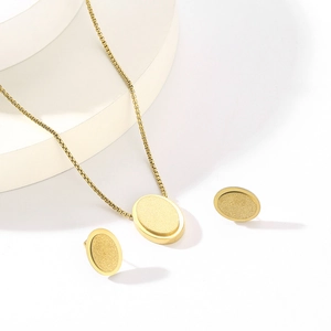 Detail of gold oval star jewelry set with necklace and earrings on white pedestal