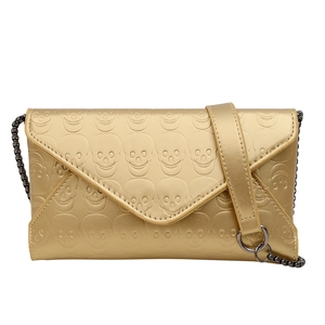 Chic matte gold envelope clutch featuring skull embossing and metallic chain strap