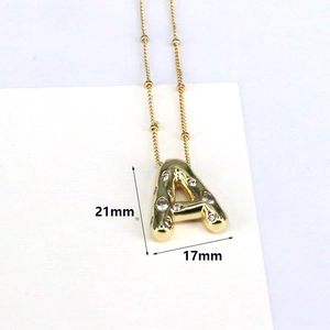 Macro detail of 18k gold plated bubble letter A pendant with zircon inlay dimensions 21x17mm